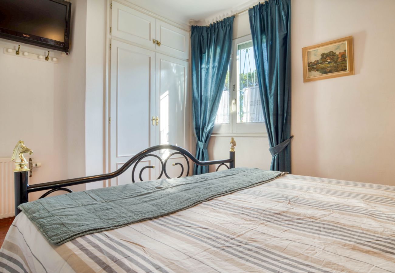 Dormitorio con armario empotrado y cortinas azules de casa en l'Escala
